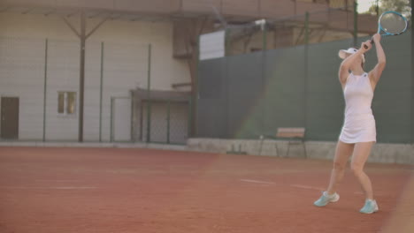 close-up of woman holding tennis racket in both hands to straighten strike. close-up of young attractive woman playing tennis at tennis court. player holding outfit. slow motion