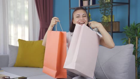 mujer joven mirando a la cámara con bolsas de compras.