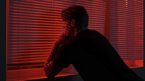 person looking out window at night
