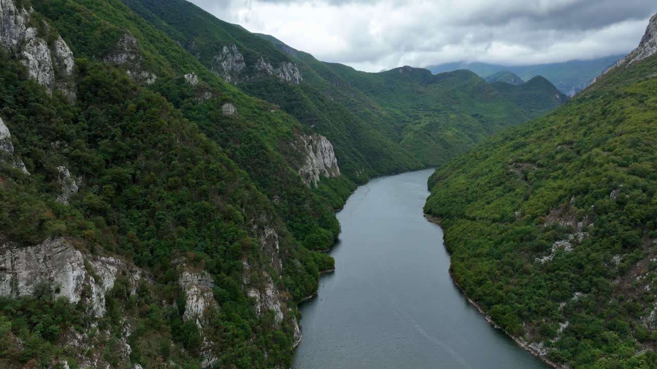 Fjord landscape by Lake Koman and green hills in Albania, forward aerial