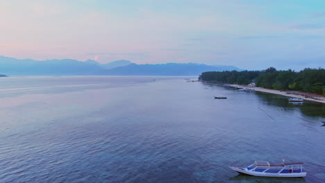 drone flying over fishing boat before sunrise at dawn in bali, indonesia