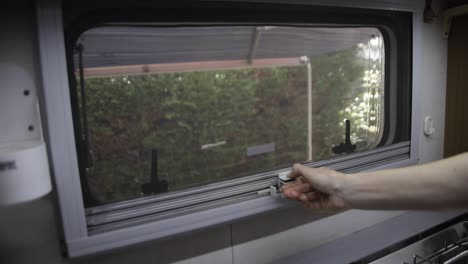 woman closing retractable pleated insect net on a motorhome side window