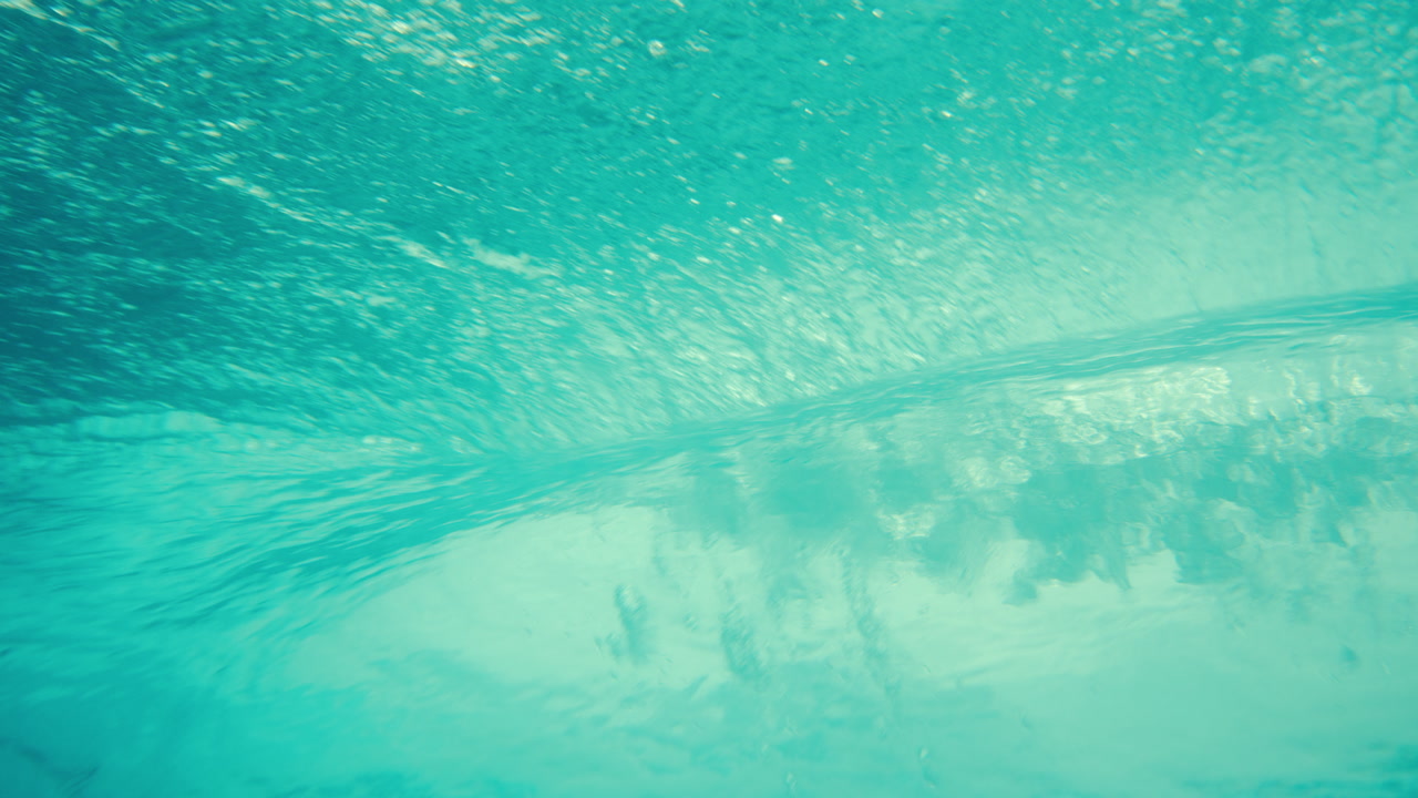 Underwater of ocean wave passing overhead with blue light filtering, slow motion