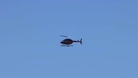 a helicopter flying steadily in clear blue sky