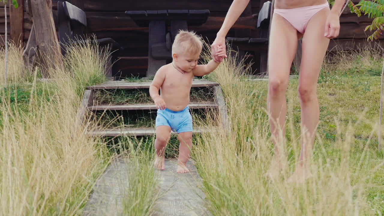 los primeros pasos del bebé el niño de 1 año va incierto a mamá video en cámara lenta