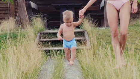 the first steps of the baby the boy of 1 year uncertainly goes to mum slow motion video