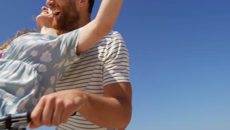 Couple-riding-bicycle-at-beach-on-a-sunny-day-4k