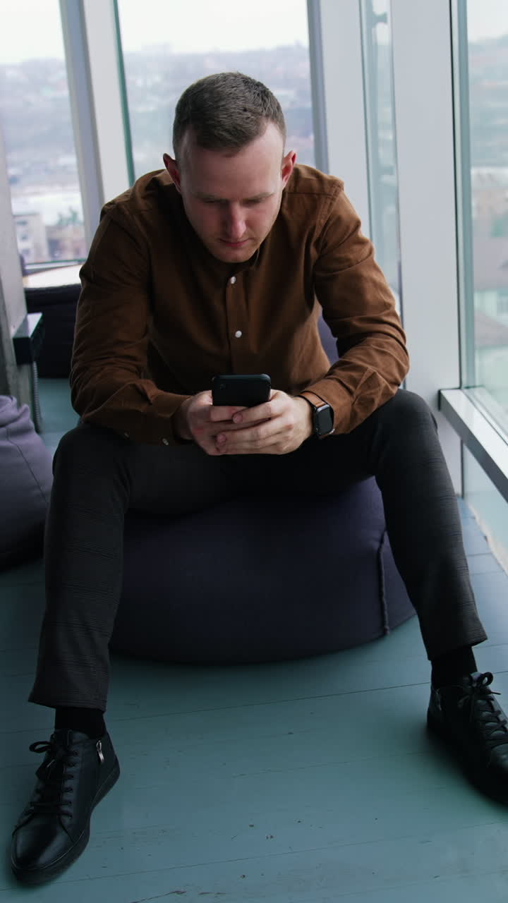 Young man using mobile phone. Work stress concept of man Vertical video