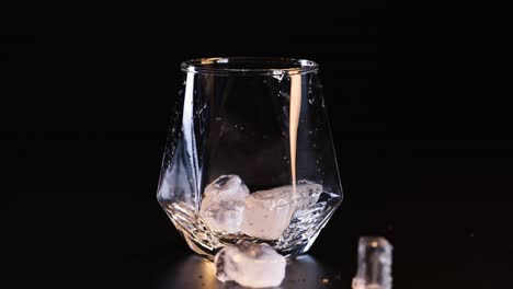 ice cubes drop into a glass sequentially