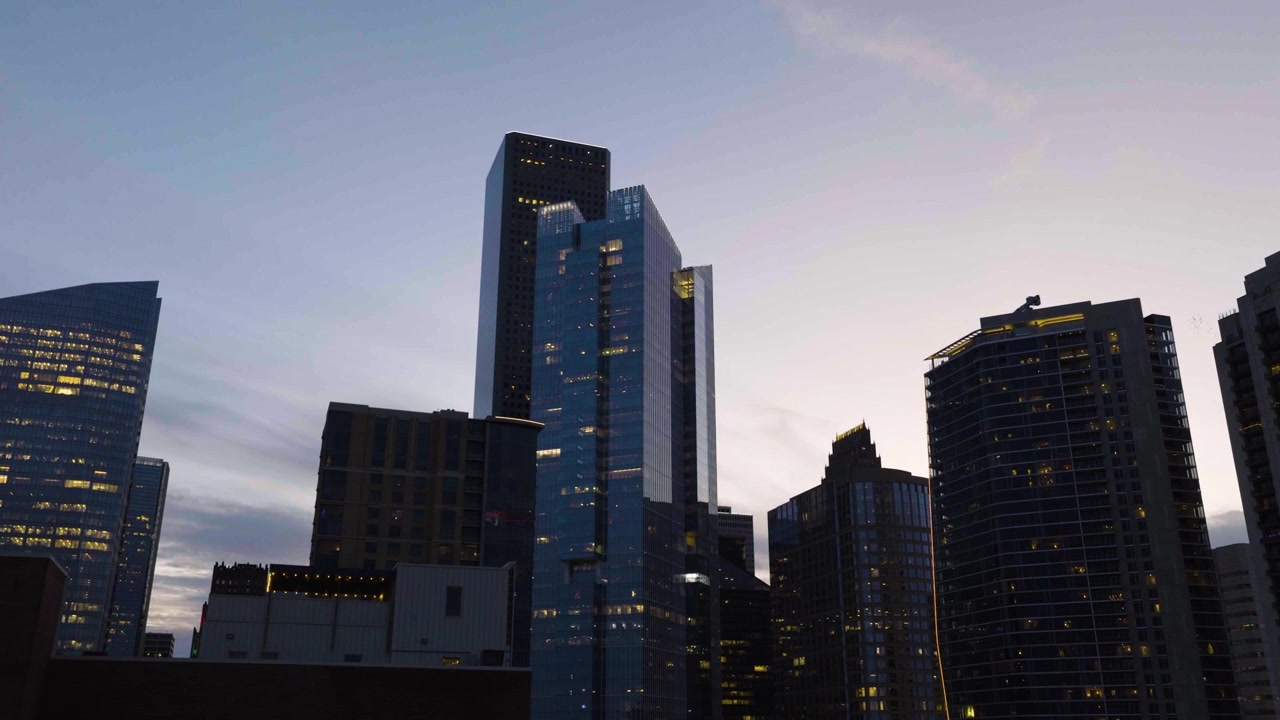 Vista aérea em ângulo baixo do skyline de Houston em direção à iluminada Texas Tower ao amanhecer