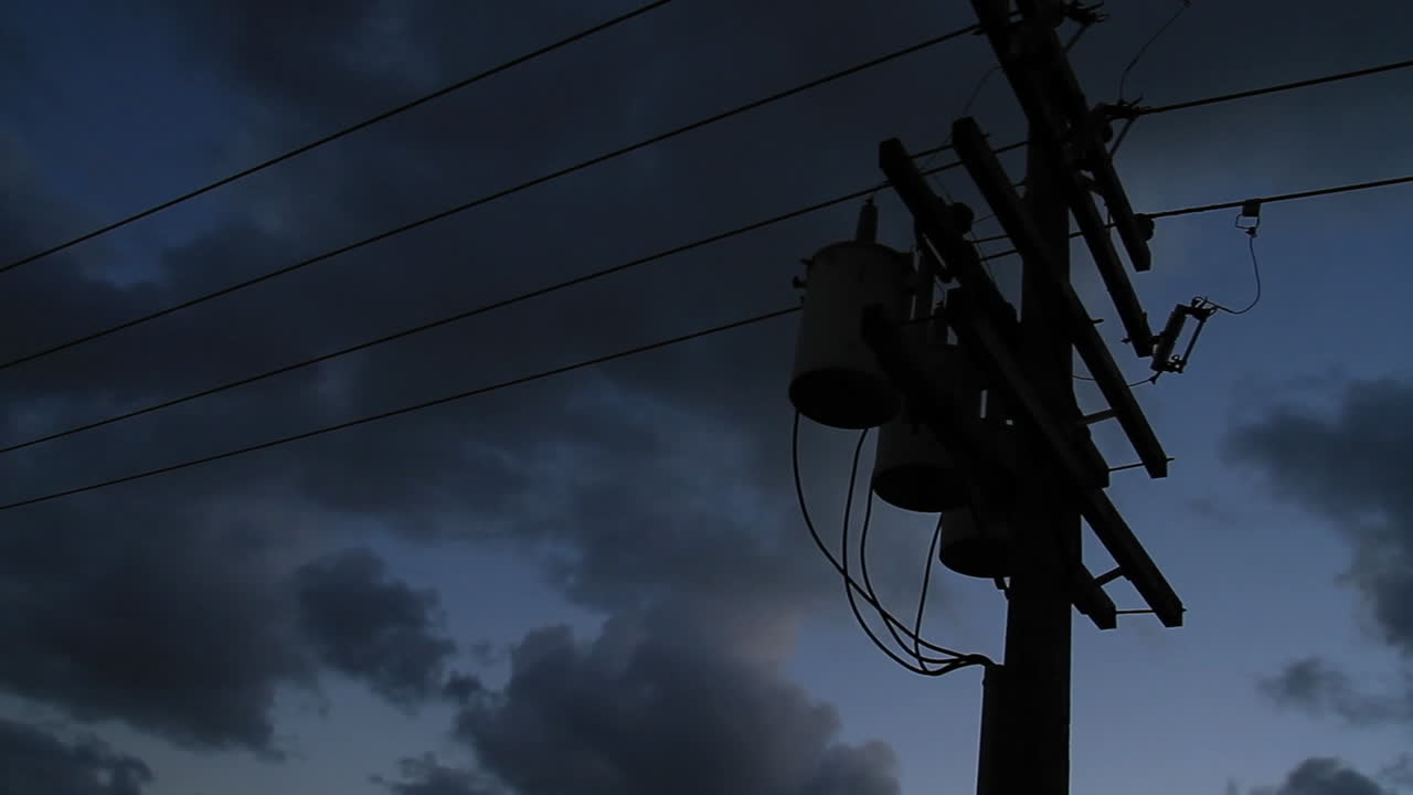 Power lines silhouetted against a dark sky 