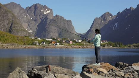 woman fishing on fishing rod spinning in norway.