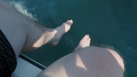 man legs wiggling over the edge of a speeding boat in dramatic light