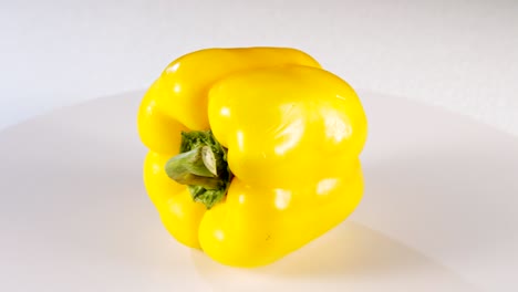 cerrar un pimiento amarillo girando sobre un fondo blanco
