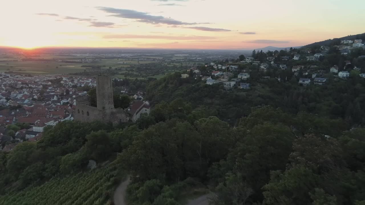 Zooming out aerial view of historic castle in Schriesheim Germany during a beautiful sunset.