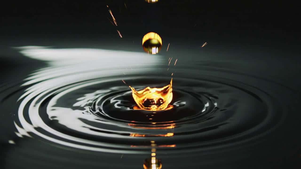 Falling golden droplet causing impact, forming crown and sending ripples on dark studio pool