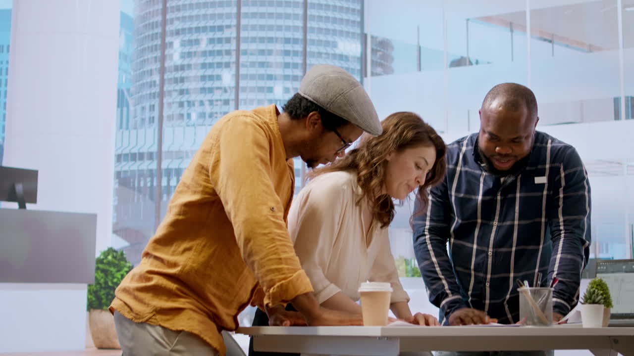 Professional clients and their realtor review blueprints and discuss investment