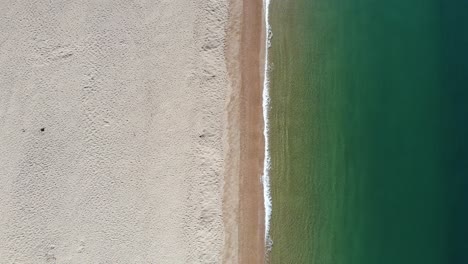 aerial downward shot of chesil beach in dorset showing beautiful turquoise waters