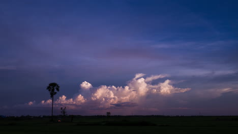 nubes de tormenta burbujeantes con siluetas de palmeras al atardecer sobre el lago tonle sap, camboya