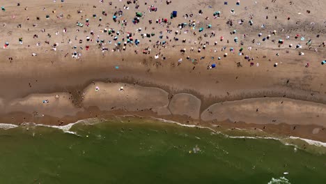 Crowed-With-People-Scheveningen-Beach-in-Den-Haag-on-Hot-Summer-Day,-Holland---Aerial-Top-Down-View