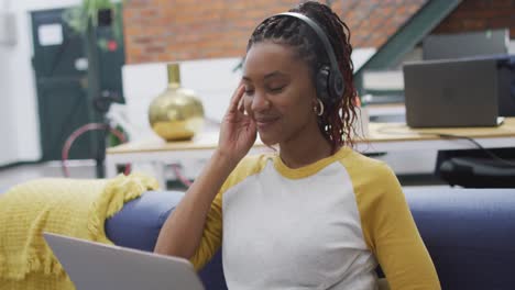 Happy-african-american-businesswoman-using-laptop-at-office