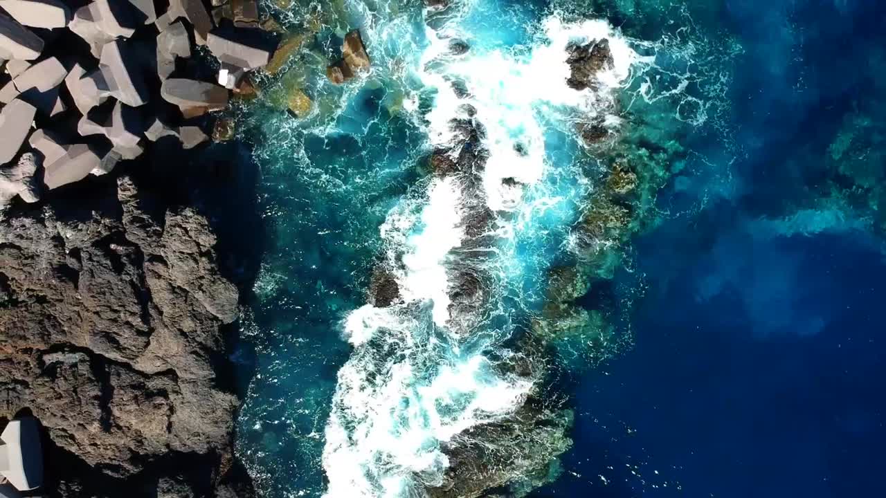 Aeriel drone footage at Garachico - Caleton (Tenerife) next to the blue ocean as the waves hit the rocks in the water