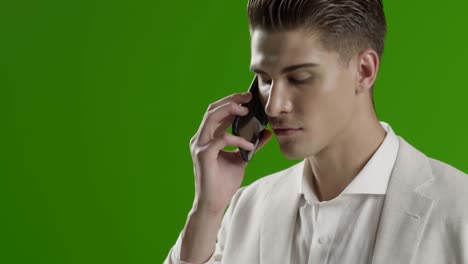 joven hombre de negocios guapo pantalla verde usando teléfono inteligente sonriendo tomando fotos selfie con el teléfono