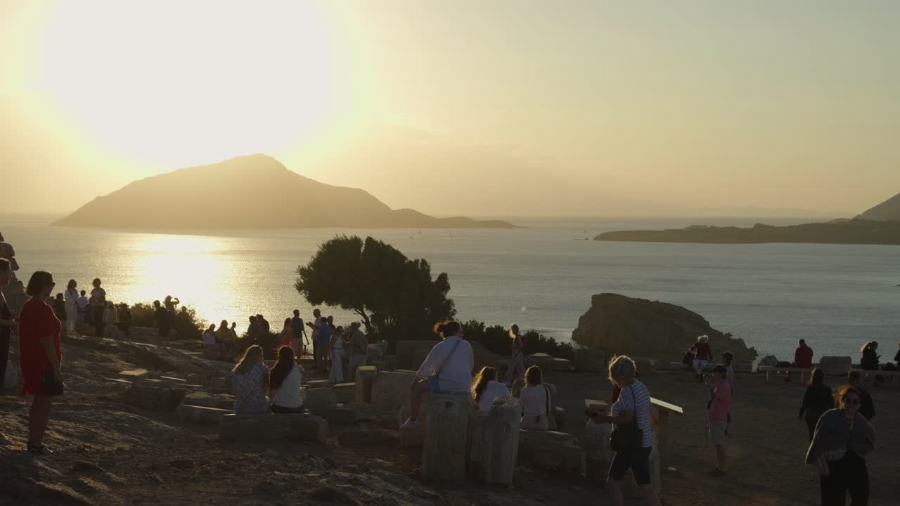 Crowds of people watching sunset from top of hill
