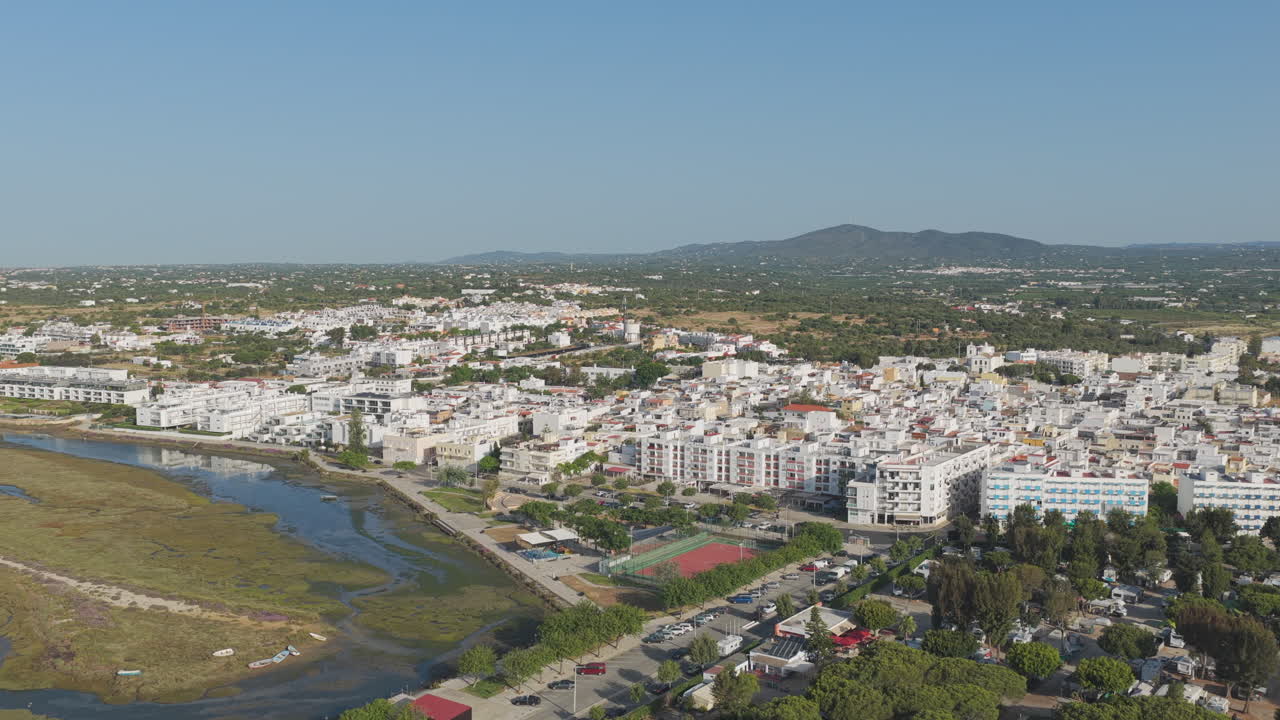 Aerial tracking shot approaching Fuseta town over Ria Formosa wetlands