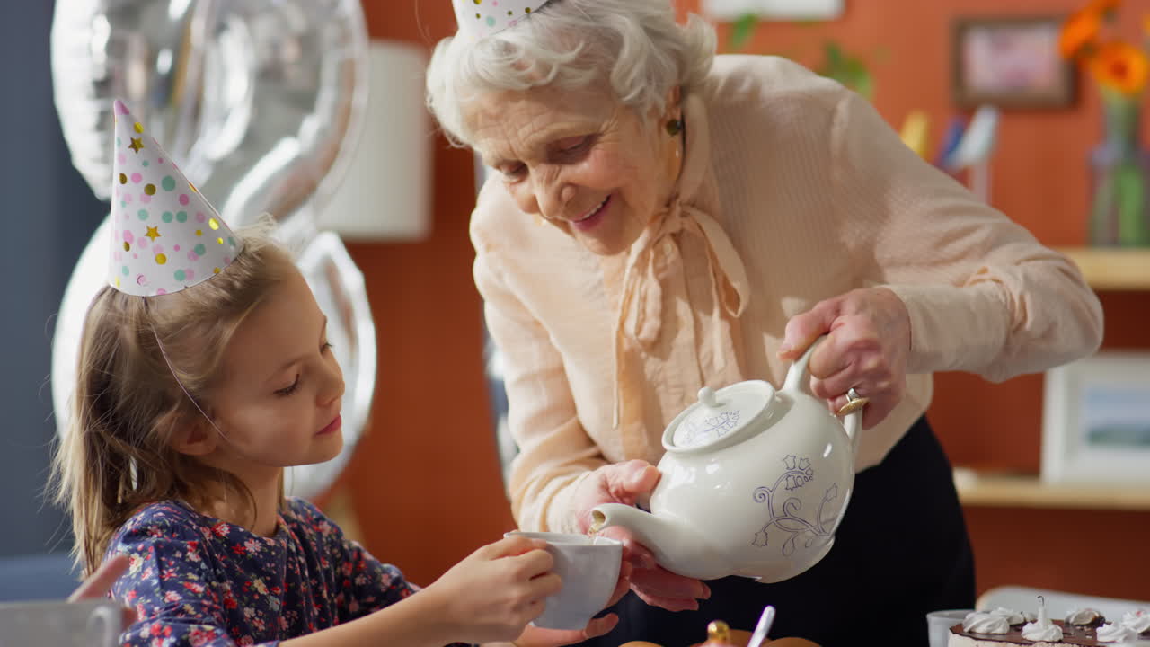 Nonna e nipote che si godono una festa del tè di compleanno