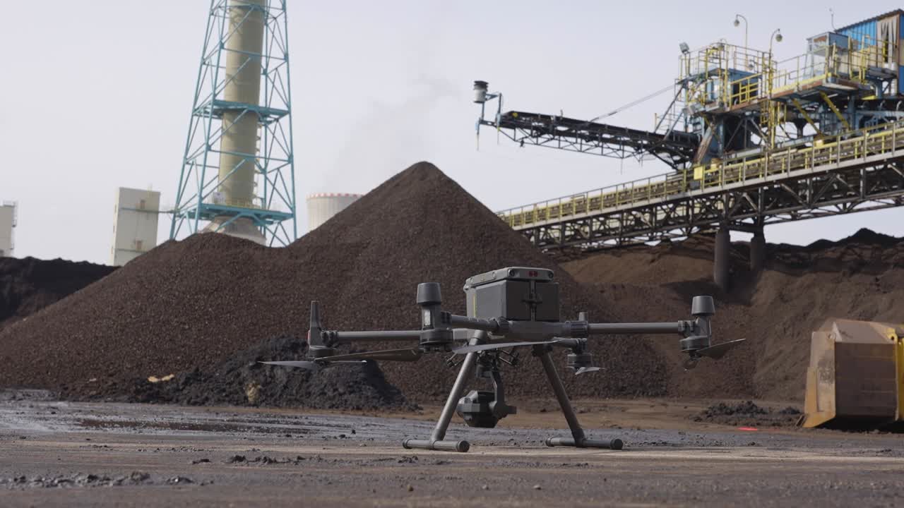 Steady slider shot of a large industrial drone on a sand plant factory
