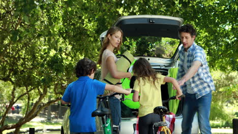 Familia-Colocando-Cosas-En-El-Maletero-Del-Coche