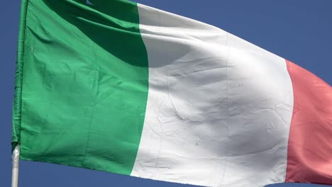 4k. italian flag waving in the wind on a blue sky. italy flag
