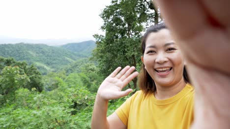 Positive-female-hipster-waving-a-hand-at-the-camera-during-video-chat-online