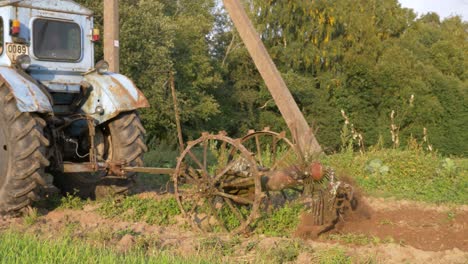 Toma-De-Cámara-De-Primer-Plano-De-La-Vieja-Máquina-Cosechadora-De-Papas-Oxidadas-Que-Sigue-Cavando