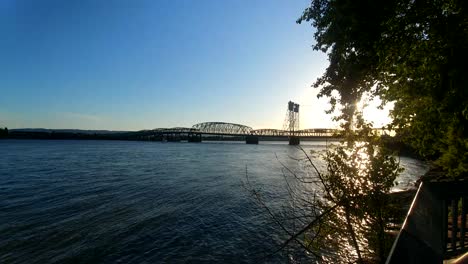 Lovely-view-of-the-Interstate-Bridge-leading-from-Vancouver,-WA-into-Portland,-OR-over-the-peaceful-and-calm-Columbia-River-at-dusk