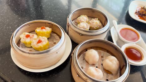 dim sum dishes served on rotating table with sauces