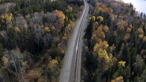 aerial dolly left over train tracks running through idyllic autumn boreal forest in the canadian shield