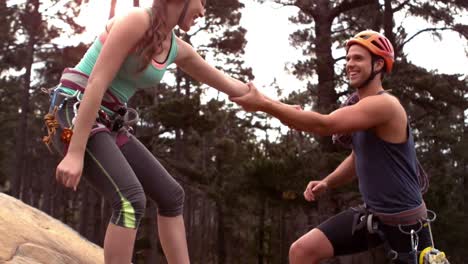 una pareja sonriente escalando rocas