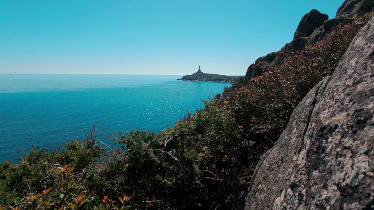 Ampia inquadratura del mare Mediterraneo turchese e della costa rocciosa a Capo Carbonara, Sardegna. Perfetto per documentari di viaggio e contenuti sul turismo del benessere.