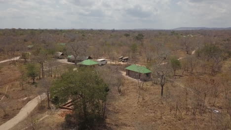 Aerial-flyover-of-tourist-bush-camp-in-dry-open-bushveld,-Zimbabwe