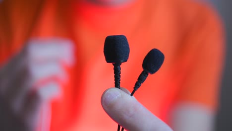 Person-showing-the-camera-3-types-of-tie-microphones