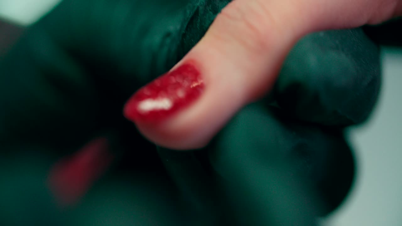 la manicurista aplica la manicura a la uña de la mujer en el salón