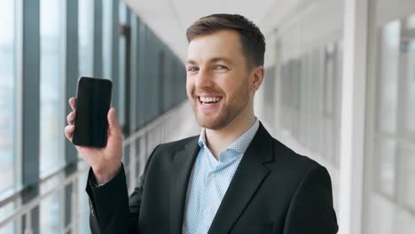 Business-man-shows-a-pack-of-money-and-a-smartphone