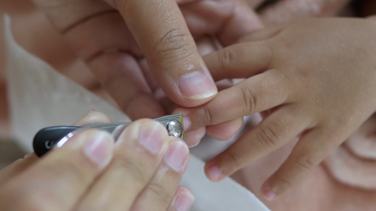A nurturing moment as a parent carefully trims a child's nails at home emphasizing care and bonding
