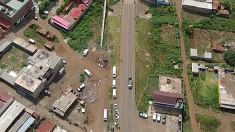 aerial view following a truck driving through a small town, in rural africa - top down, drone shot