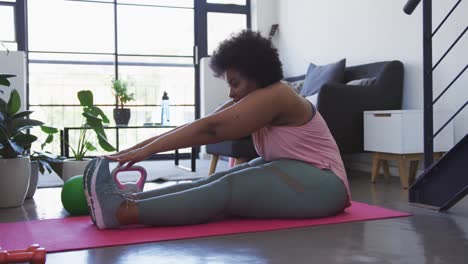 Afroamerikanische-Frau-In-Übergröße,-Die-Auf-Einer-Trainingsmatte-Sitzt-Und-Trainiert