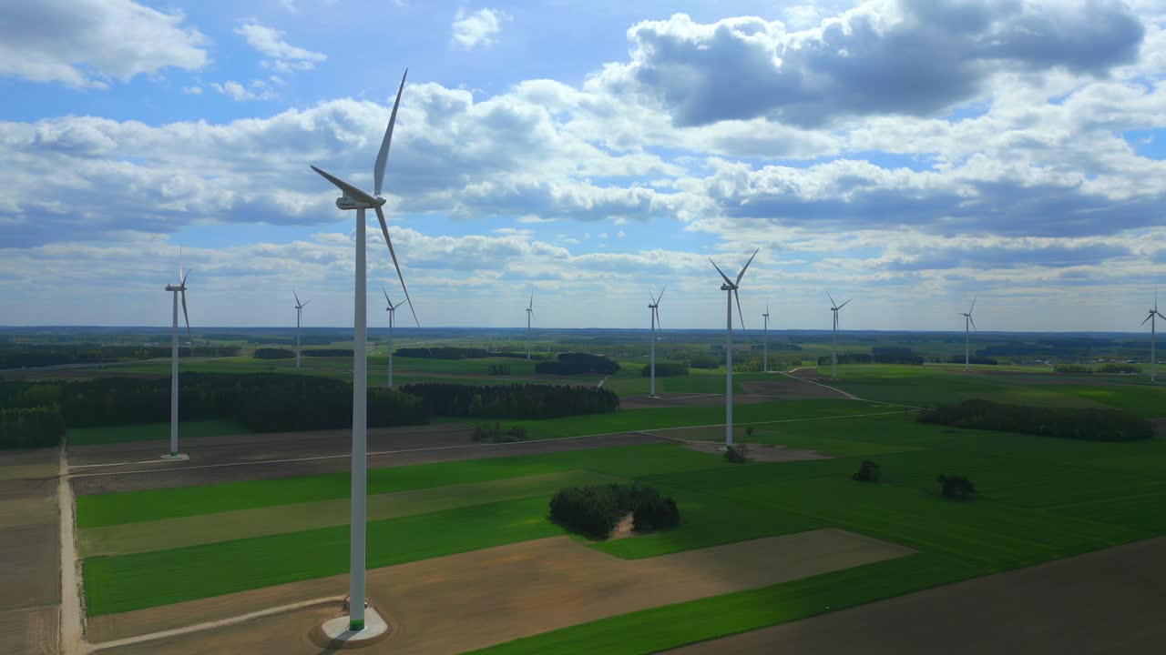 ⁇ 은 날에 풍력 발전소를 통과하고, 하늘은  ⁇ 은 구름으로 가득 차 있으며, 터빈과 잘 관리된 농지를 촬영하고 있습니다.