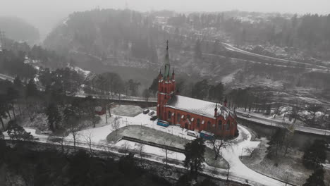 Aerial-View-Of-Trollhattan-Church-In-Trollhattan,-Sweden-During-Snowfall-In-Winter