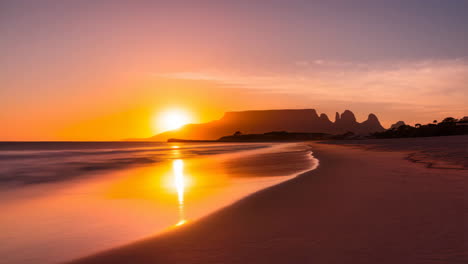 sunset on a beach with table mountain in the background